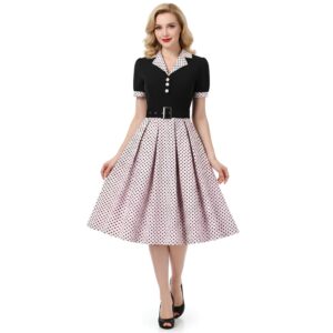 Ribe élégante à pois avec le noir et col chemise et le bas blanc à pois noirs. Portée par une femme blonde à la coiffure vintage.