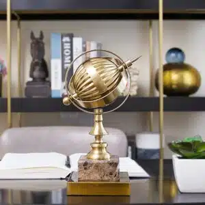 Globe métal doré, socle marbre très à la mode. Sur une table de bureau dans une maison