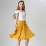 Jupe mi-longue plissée, porté par une femme. Très à la mode. Bonne qualité
