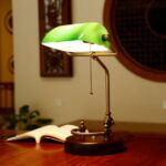 Lampe de bureau verte vintage en bois de bouleau sur une table dans une maison