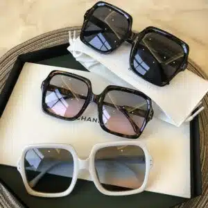 Grosses lunettes de soleil des années 60. Elles ont une forme carrée et des verres pas trop opaques. Les montures sont épaisses.