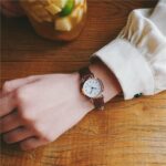 Montre à quartz vintage avec bracelet de simili cuir à la mode portée par une femme