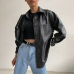 Veste en imitation cuir longue noire, très bonne qualité portée par une femme.
