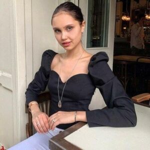 Chemisier vintage à manches bouffantes pour femme, couleur noir. Bonne qualité et très tendance portée par une femme.