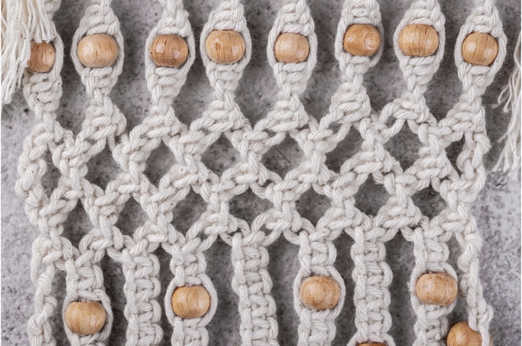 vue rapproché sur une des noeuds de macramé avec des perles