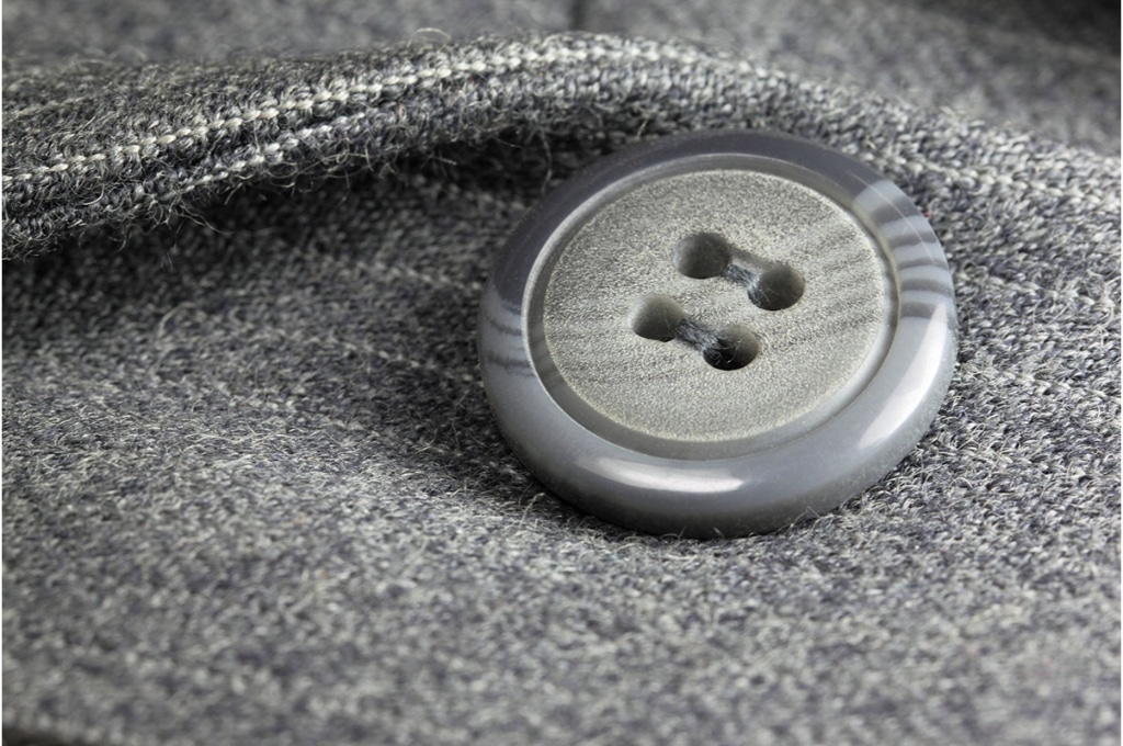 plan très rapproché sur un bouton gris sur un manteau gris
