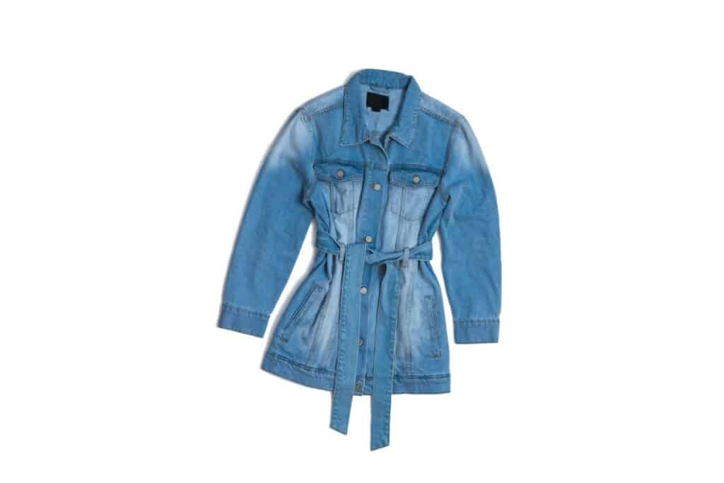 chemise vintage en jean sur fond blanc avec une ceinture en jean nouée autour de la taille.