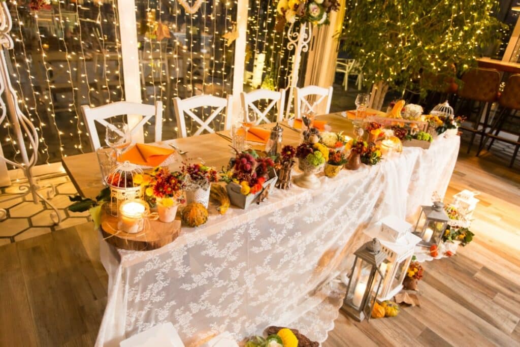 Table d'invités à un mariage vintage. Beaucoup d'éléments de décoration sont disposés sur la table dans un style printanier.