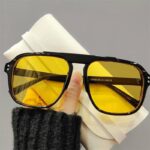 Lunette de soleil rétro avec verre jaune et main de femme qui tient les lunettes