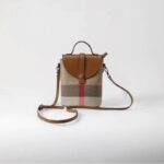 Sac à main carré et rétro marron et beige avec petite sangle sur le dessus et sangle pour le porter à l'épaule