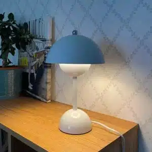 Lampe de style nordique de couleur bleu posée un meuble en bois avec un vase à plante