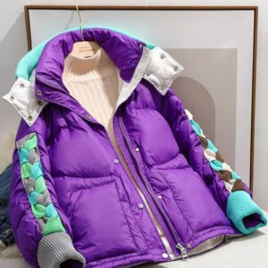 Doudoune vintage de couleur violette avec des touches de couleur bleu, vert et gris, posée sur un cintre avec un pull beige