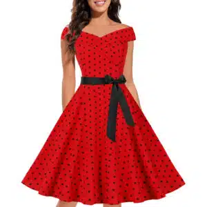jeune femme dont on ne voit pas le visage , porte une robe rouge vintage avec noeud noir à la taille et pois noirs, elle est présentée sur fond blanc