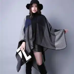 Écharpe femme vintage à carreaux gris portée par une femme avec un chapeau noir et des bottes noires portant un sac à main noir et blanc