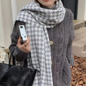 Écharpe femme vintage à motifs gris portée par une femme avec un haut gris tenant un sac à mai noir et un appareil photo gris