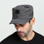 Casquette vintage de couleur grise, portée par un homme avec un haut noir