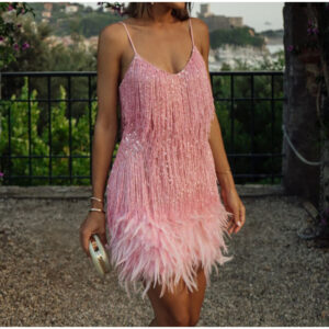 Robe Charleston rose à franges et plumes portée par une jeune femme