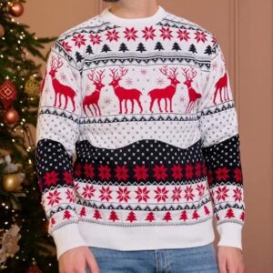 Homme debout de face, devant un sapin dans un salon, portant un jean et un pull blanc de Noël à motifs