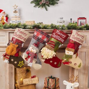 4 chaussettes différentes de Noël suspendues à une cheminée, décorée avec des éléments de Noël