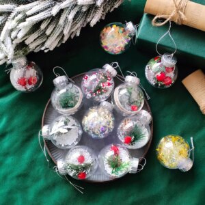 12 boules de Noël transparentes remplies d'éléments colorés, disposées dans un décor de Noël.
