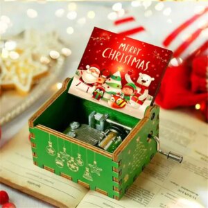 Boite à musique en bois verte et rouge sur le thème de Noël posée sur un livre ouvert avec un décor de fête