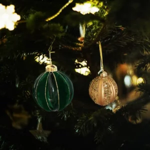 2 boules de couleur vert et doré dans un sapin de Noël.