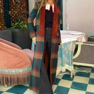 Ue femme blonde portant un manteau long à carreaux dans un petit salon au look vintage.