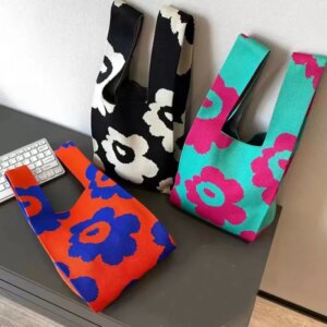 Trois mini sacs-à-main avec des motifs de grosses fleurs posés sur une table.